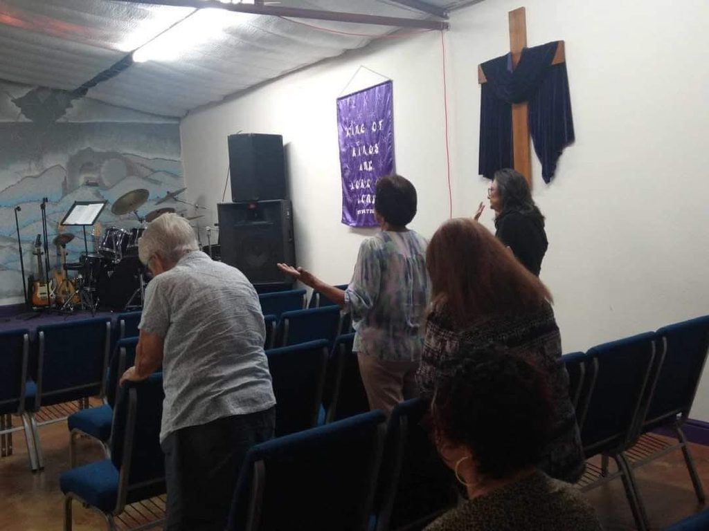 Members of the church gathered in prayer before the cross